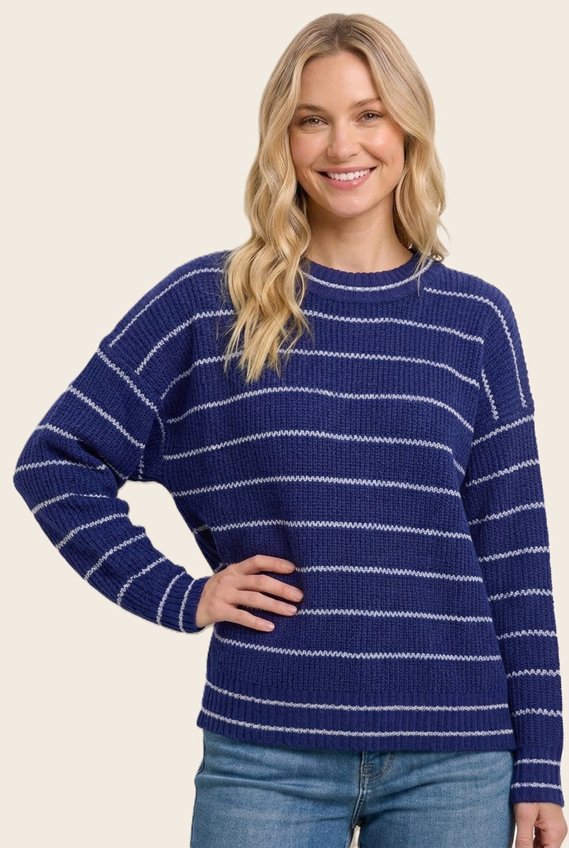 woman wearing a navy blue striped sweater with white accents and relaxed fit, paired with light blue jeans