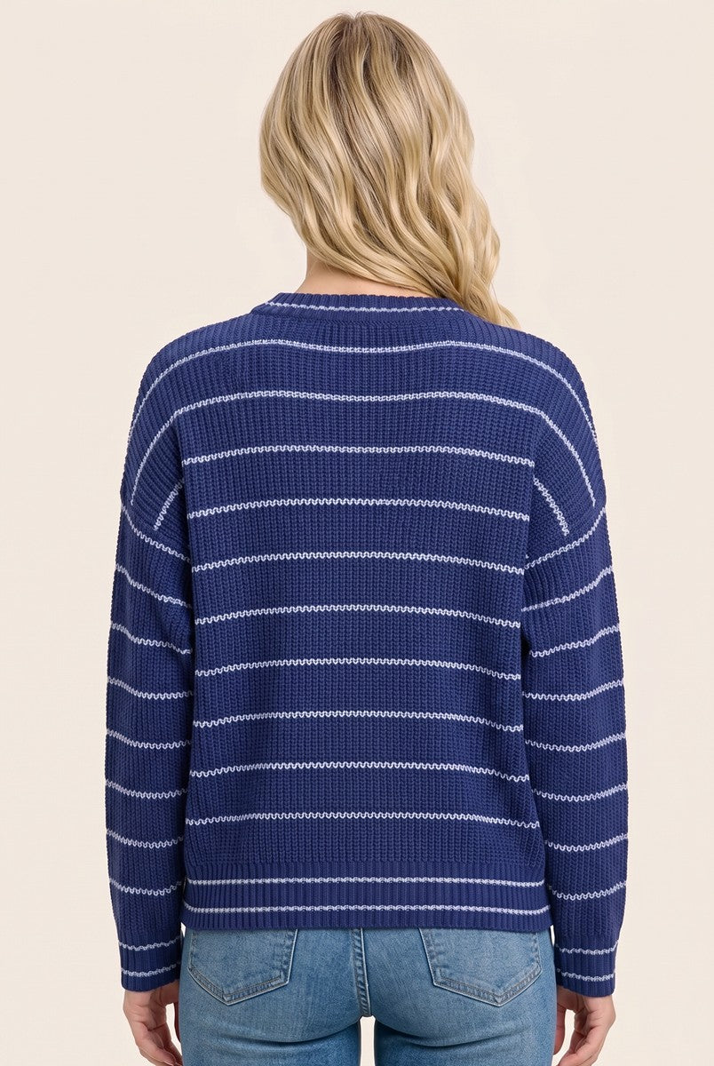 woman wearing a navy blue striped sweater with a relaxed fit and long sleeves, viewed from the back