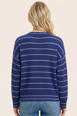 woman wearing a navy blue striped sweater with a relaxed fit and long sleeves, viewed from the back