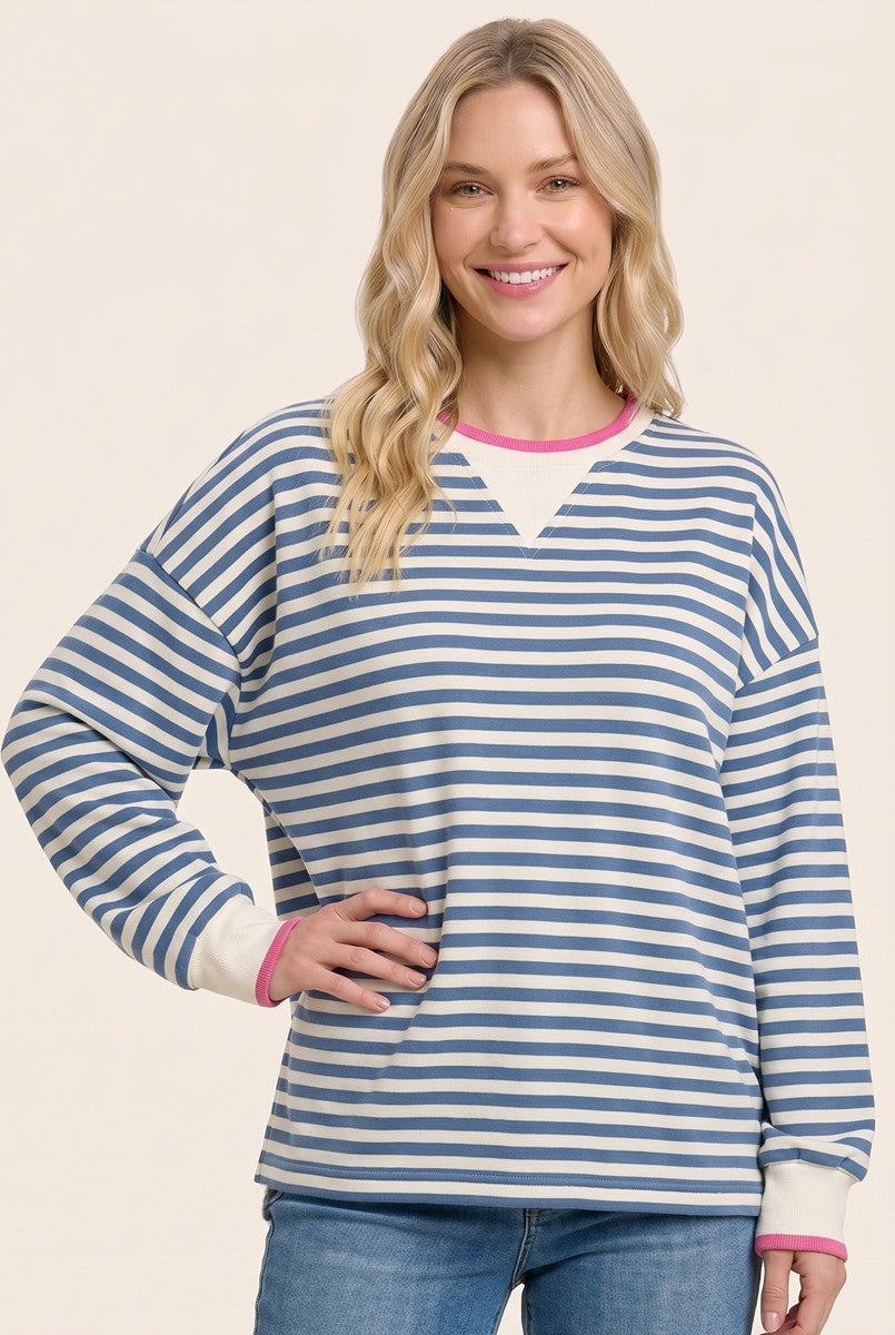 woman wearing a blue and white striped oversized sweatshirt with pink trim details
