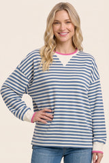 woman wearing a blue and white striped oversized sweatshirt with pink trim details