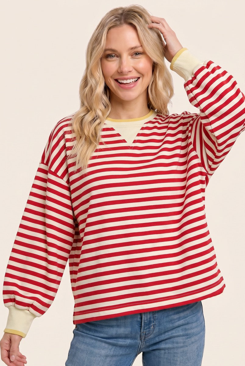 woman wearing a red and cream striped oversized sweatshirt with balloon sleeves and a v-neckline