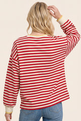 woman wearing a red and white striped long sleeve shirt with yellow cuffs, showing the back view