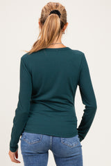 woman wearing a dark green long sleeve maternity top viewed from the back with fitted design and casual style