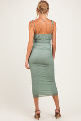 woman wearing a green maternity bodycon dress with adjustable straps and a midi length, showing a baby bump from the back