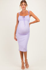 woman wearing a lavender maternity dress with tie straps and a fitted silhouette, showcasing her baby bump