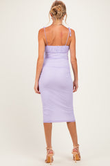 woman wearing a lavender maternity midi dress with adjustable straps and a fitted silhouette, showing no baby bump
