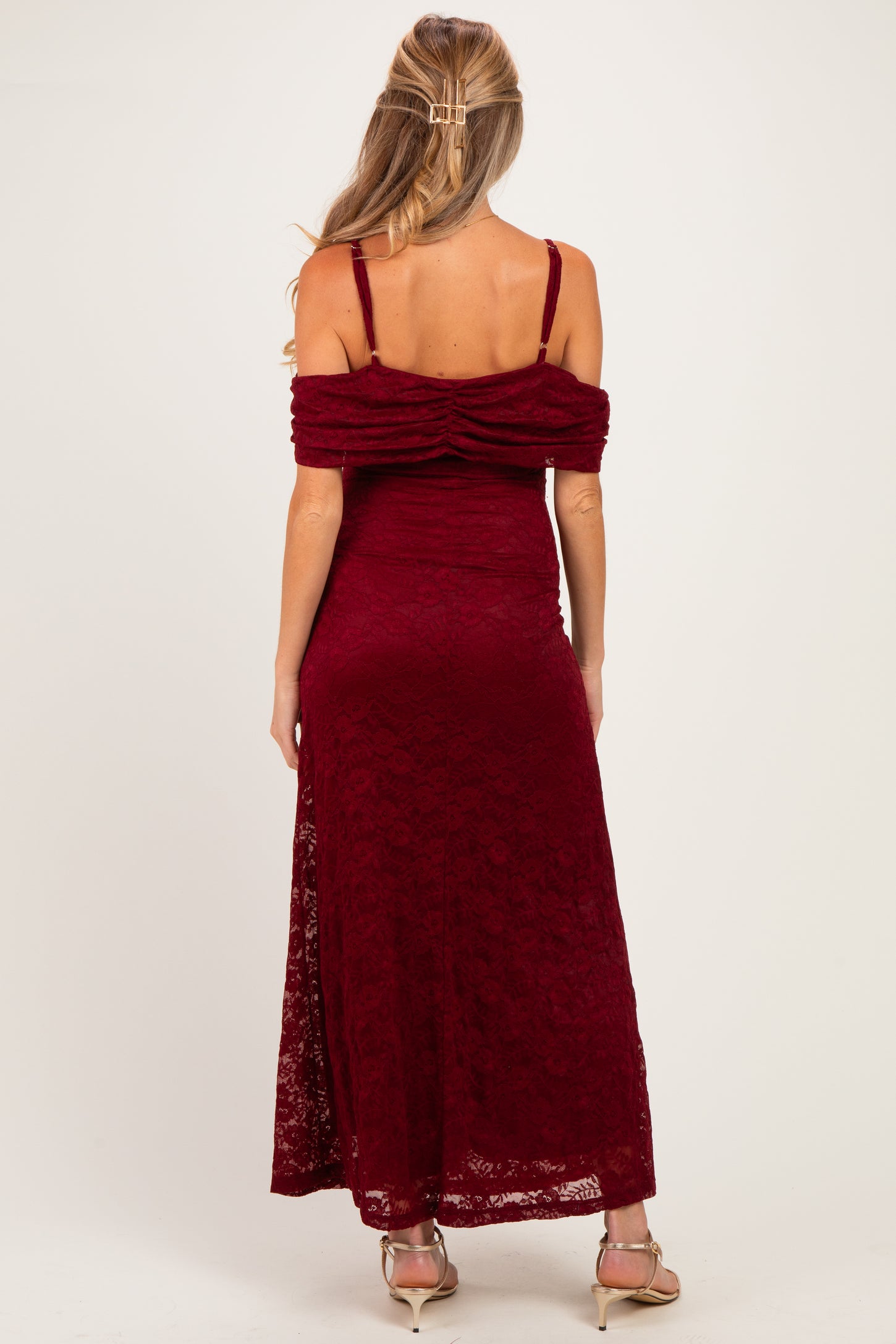 woman wearing a burgundy lace off-the-shoulder maternity dress, showing pleated details on the back