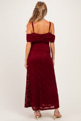 woman wearing a burgundy lace off-the-shoulder maternity dress, showing pleated details on the back