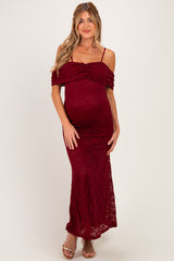 woman wearing a burgundy lace off-the-shoulder maternity dress with a fitted silhouette and a visible baby bump