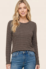 woman wearing a brown striped long sleeve top paired with blue jeans