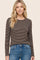 woman wearing a brown striped long sleeve top paired with blue jeans