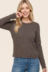 woman wearing a brown and cream striped long sleeve top paired with blue jeans