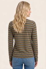 woman wearing a brown and gray striped long sleeve top, seen from the back with wavy blonde hair