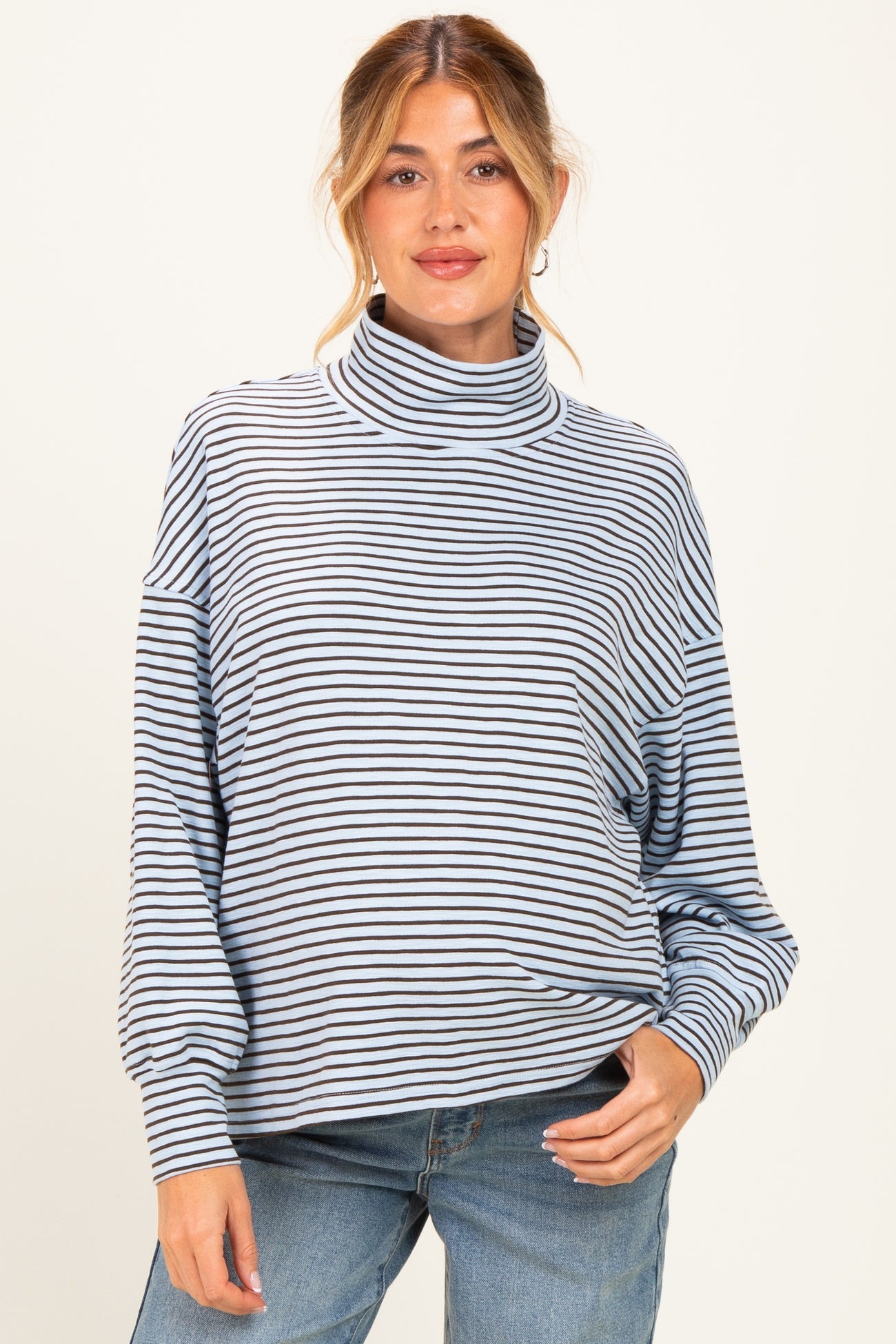 woman wearing a striped maternity top with a funnel neck and relaxed fit