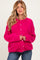woman wearing a bright pink maternity cardigan with buttons, styled casually with jeans