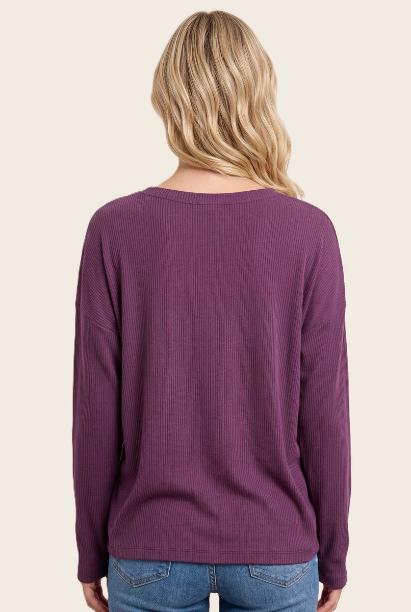 woman wearing a purple ribbed long sleeve top with a relaxed fit and scoop neckline, viewed from the back