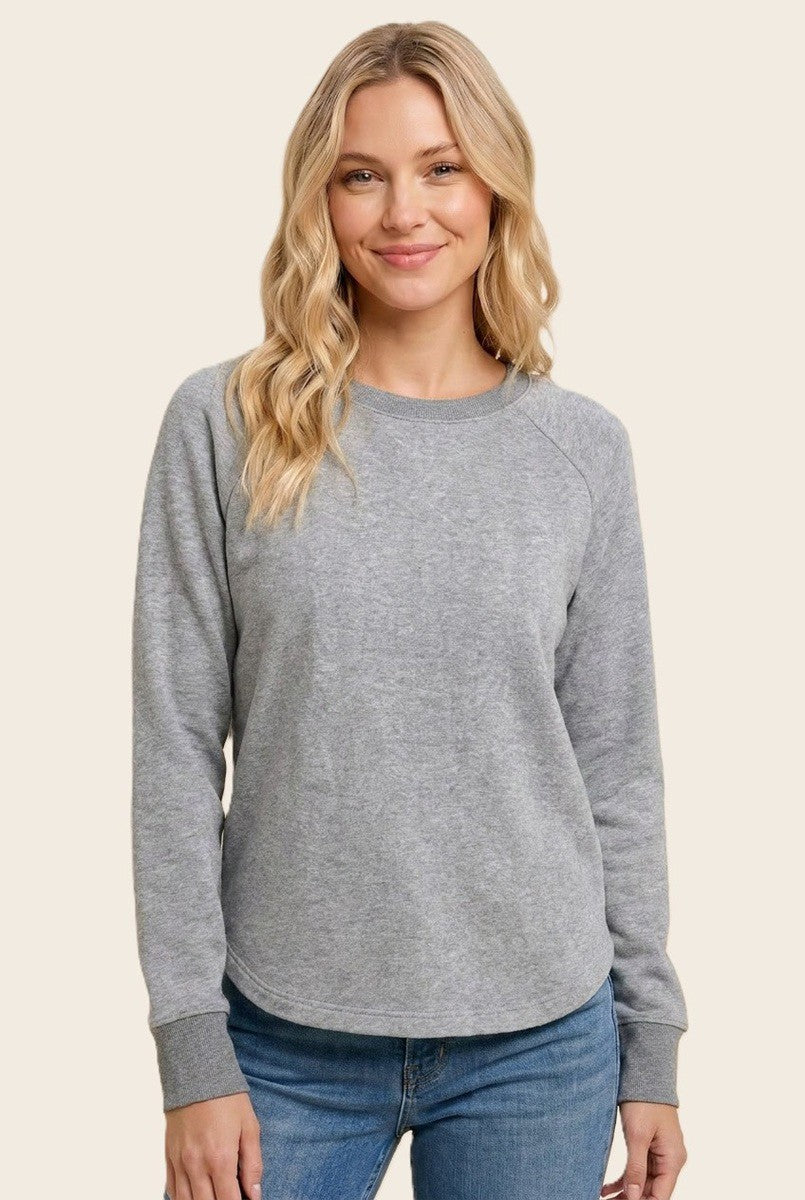 woman wearing a gray long sleeve sweatshirt with a round neckline and raglan sleeves