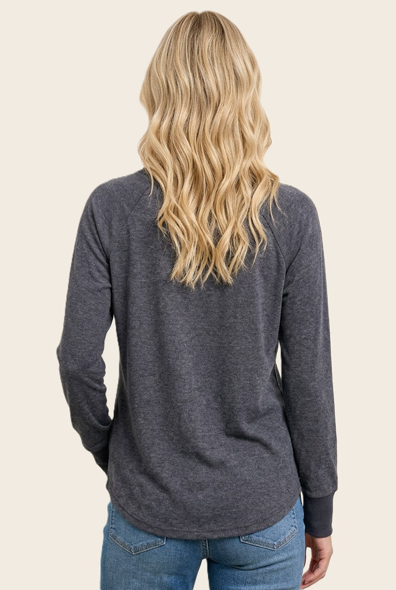 woman wearing a dark gray long sleeve top with a relaxed fit, seen from the back with wavy hair down