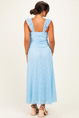 woman wearing a light blue maternity dress with ruffled straps and a fitted bodice, showing a flowing skirt from the back