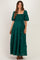 woman wearing a green maternity maxi dress with puff sleeves and floral lace details