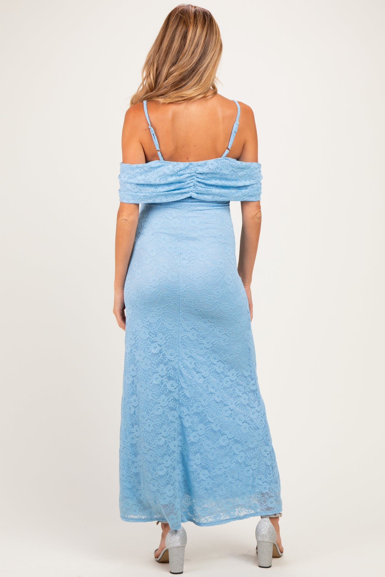 woman wearing a light blue off-the-shoulder lace maternity dress, showcasing the back view