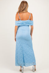 woman wearing a light blue off-the-shoulder lace maternity dress, showcasing the back view