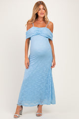 woman wearing a light blue lace off-shoulder maternity dress with a visible baby bump