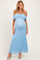 woman wearing a light blue lace off-shoulder maternity dress with a visible baby bump