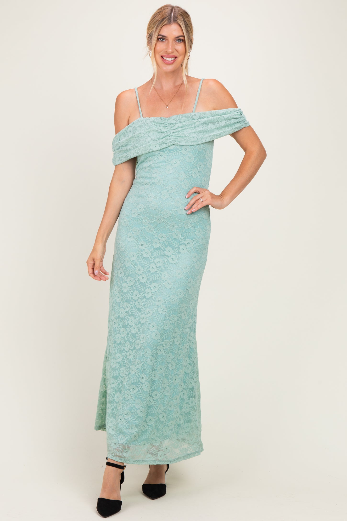 woman wearing a mint green off-the-shoulder lace maxi dress with fitted silhouette and spaghetti straps