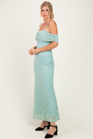woman wearing a mint green lace off-the-shoulder maxi dress with a ruched bodice and spaghetti straps
