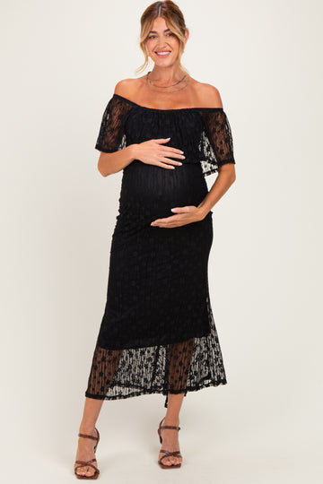 woman wearing a black off-the-shoulder maternity dress with lace detailing and a baby bump visible