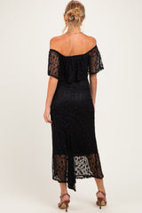 woman wearing a black off-the-shoulder maternity dress with a flowy design and a mid-length hemline