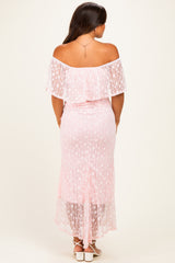 woman wearing a pink off-the-shoulder maternity dress with lace details and a high-low hem, showing a baby bump