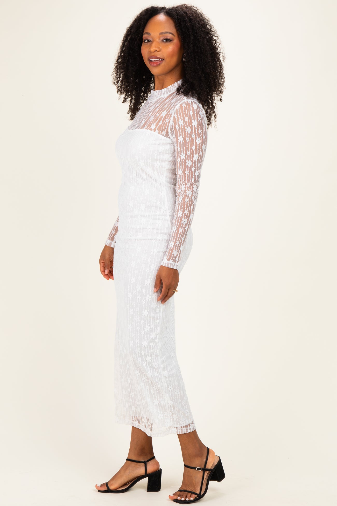 woman wearing a white long sleeve sheer dress with star pattern and form-fitting silhouette