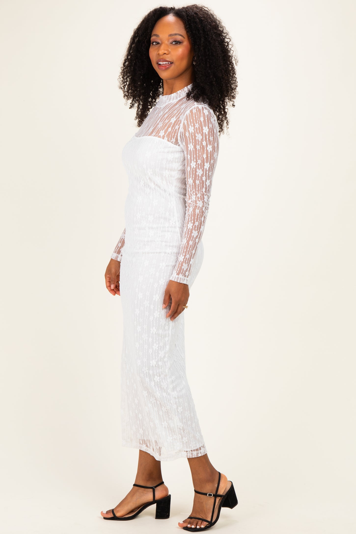 woman wearing a white long sleeve sheer dress with star pattern and form-fitting silhouette
