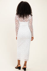 woman wearing a white long sleeve star-patterned dress with a fitted silhouette and a sheer overlay