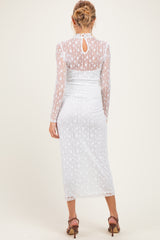 woman wearing a sheer white maternity dress with long sleeves and a bodycon fit, showing a baby bump from the back