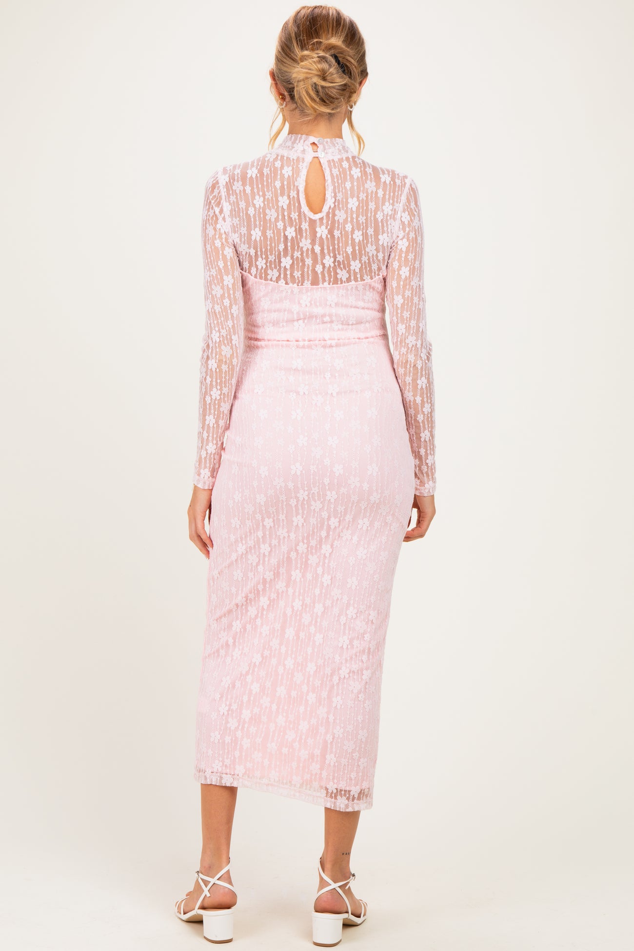 woman wearing a pink maternity lace dress with long sleeves and a keyhole back detail