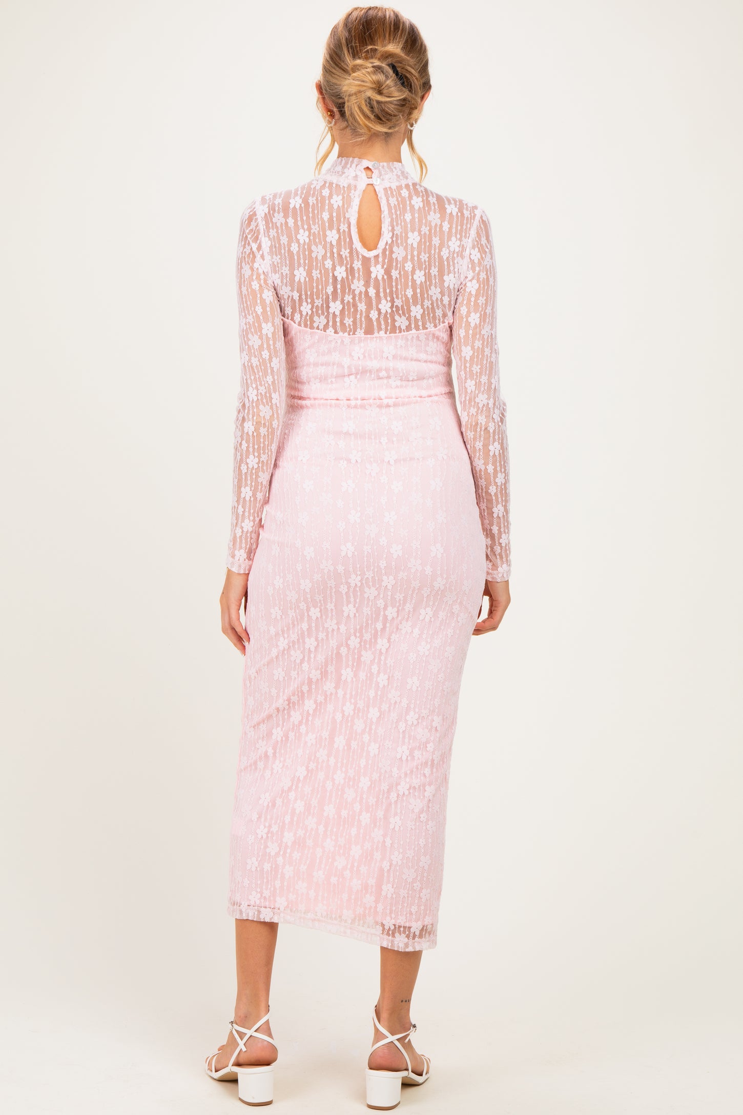 woman wearing a pink maternity lace dress with long sleeves and a keyhole back detail
