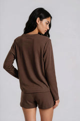 woman wearing a brown long sleeve top and matching shorts, styled for a casual look