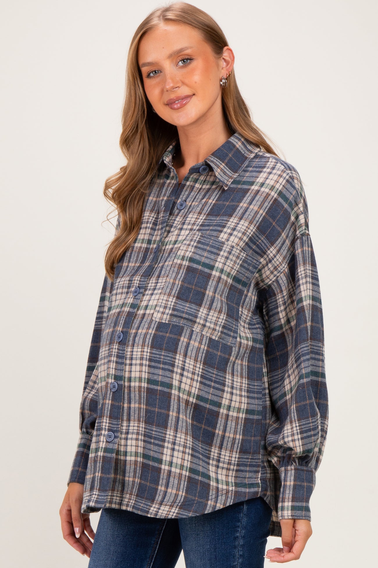 woman wearing a navy and green plaid maternity shirt with a visible baby bump