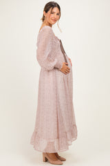 woman wearing a floral print long sleeve maternity dress, gently holding her baby bump while standing sideways