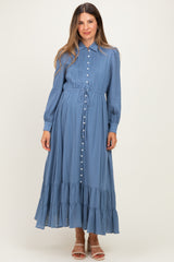 woman wearing a blue maternity maxi dress with button details and a tiered ruffle hem
