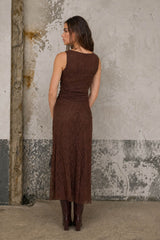 woman wearing a brown lace maxi dress with a fitted silhouette, viewed from the back