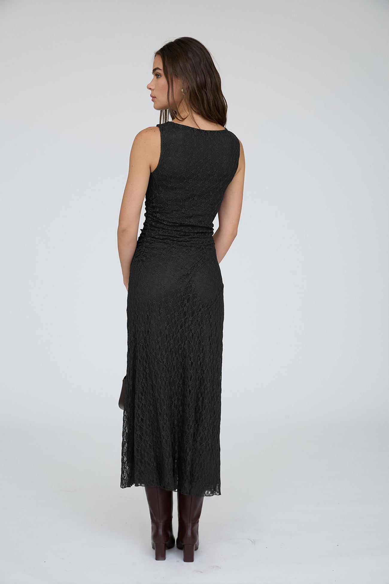 woman wearing a black lace sleeveless dress, viewed from the back, with a form-fitting silhouette and a midi length