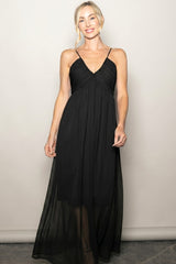 woman wearing a black maxi dress with spaghetti straps and gathered detailing at the bodice