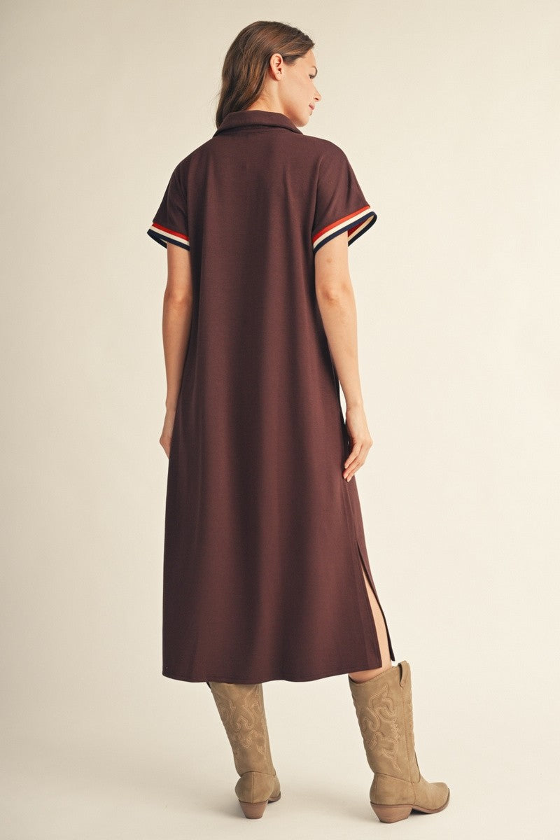 woman wearing a brown short sleeve collared dress with side slits and contrasting striped details on sleeves