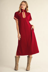 woman wearing a burgundy midi dress with a zip-up collar and striped detail, paired with brown cowboy boots