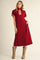woman wearing a burgundy midi dress with a zip-up collar and striped detail, paired with brown cowboy boots